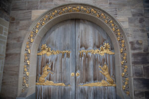 Détails de dorure d'une porte arrondie en bois avec sculpture en métal doré de lion et de licorne